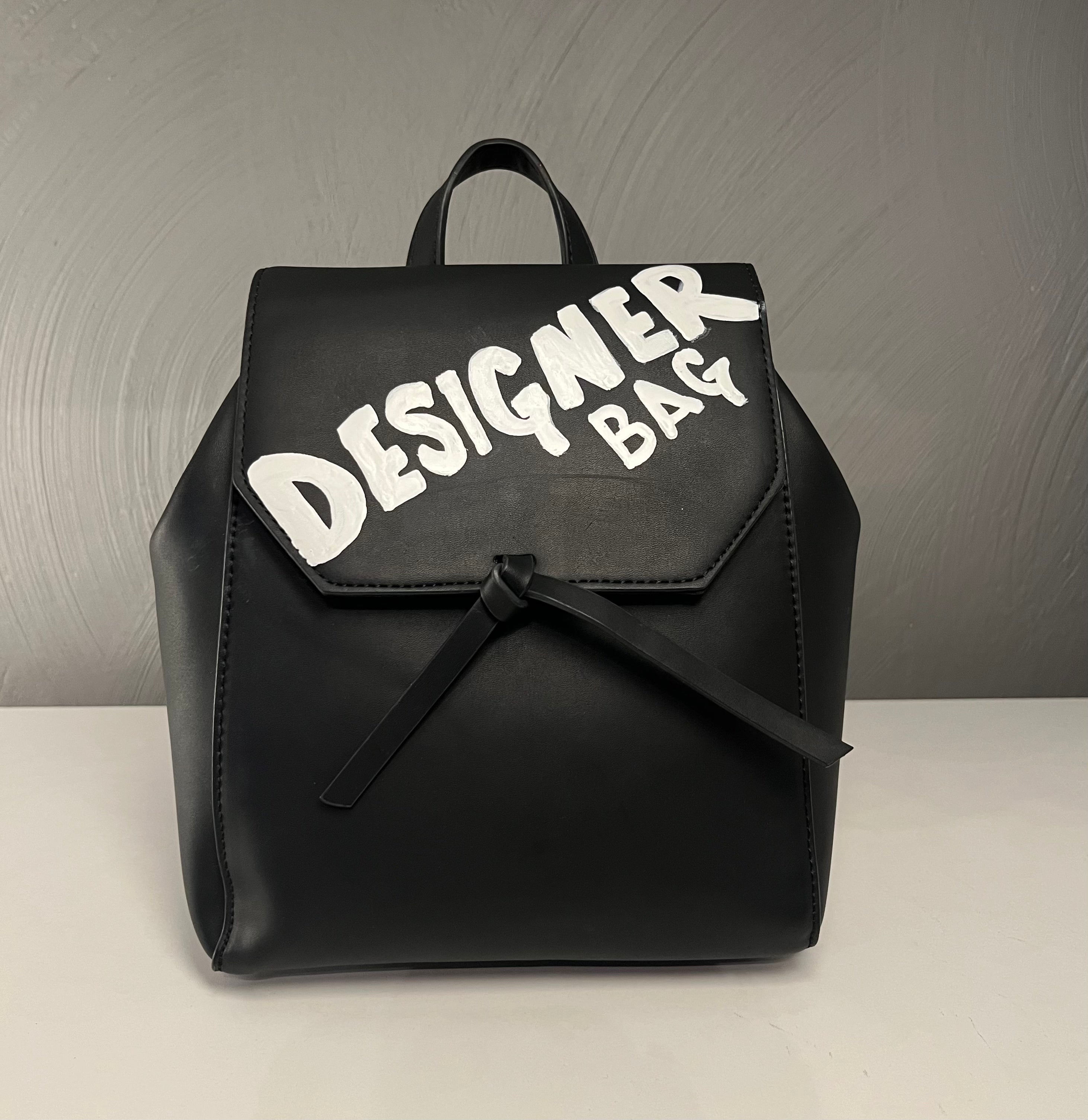 I got your back. Designer bag.